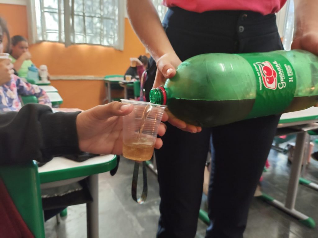 Criança recebendo guaraná.