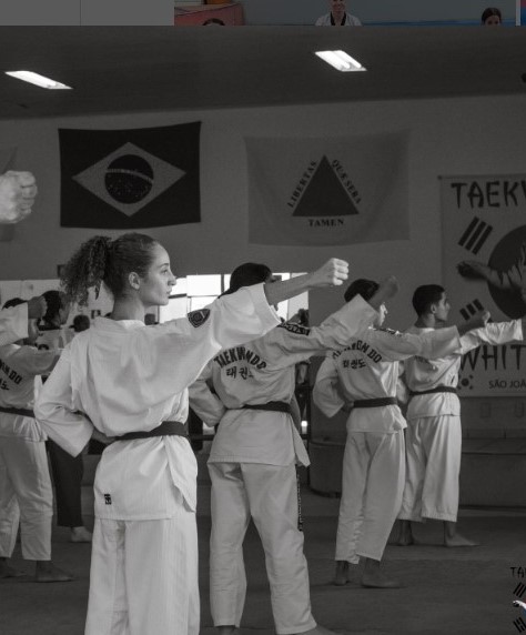 Alunos lutando taekwondo na academia.