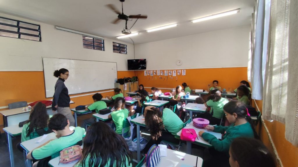 Voluntária dando aula de filosofia para alunos do quinto ano.