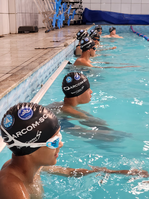 Alunos uniformizados na piscina.