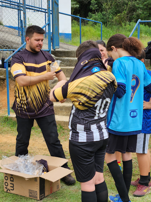 Coordenador dando uniforme para os alunos.